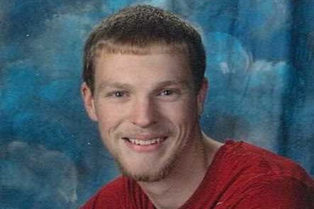 smiling young man wearing a red shirt