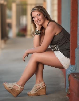 smiling young woman sitting on stoops and leaning on her knees