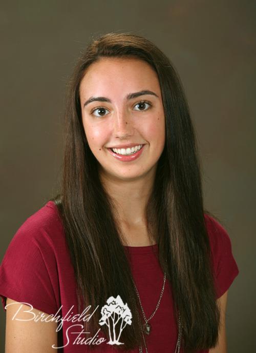 studio portrait of smiling young woman with long dark hair