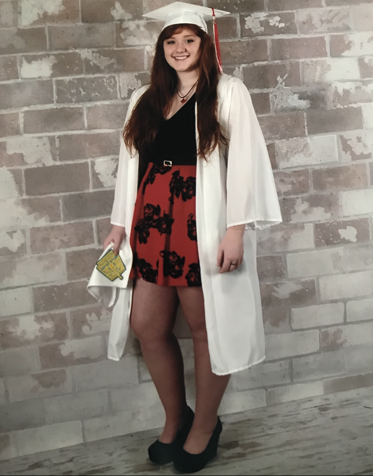 smiling young woman in white cap and gown
