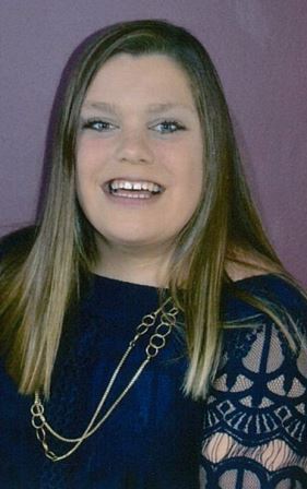 smiling young woman with lacy dark blue top and long necklace