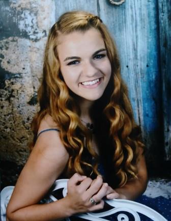 smiling young woman leaning on a white chair