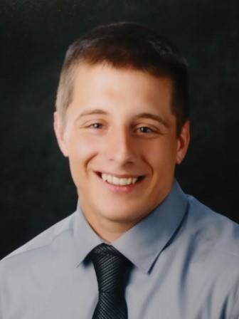 studio portrait of smiling young man with collared shirt and tie