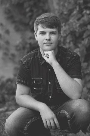 young man posing with fist on his chin leaning on knee