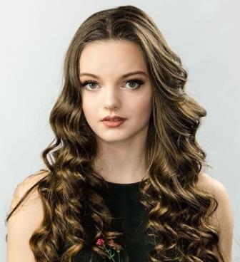 portrait of a young woman with large brown eyes and long wavy hair