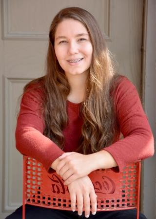 smiling woman leaning on a red chair