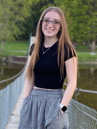 young smiling woman with long hair posing on a bridge
